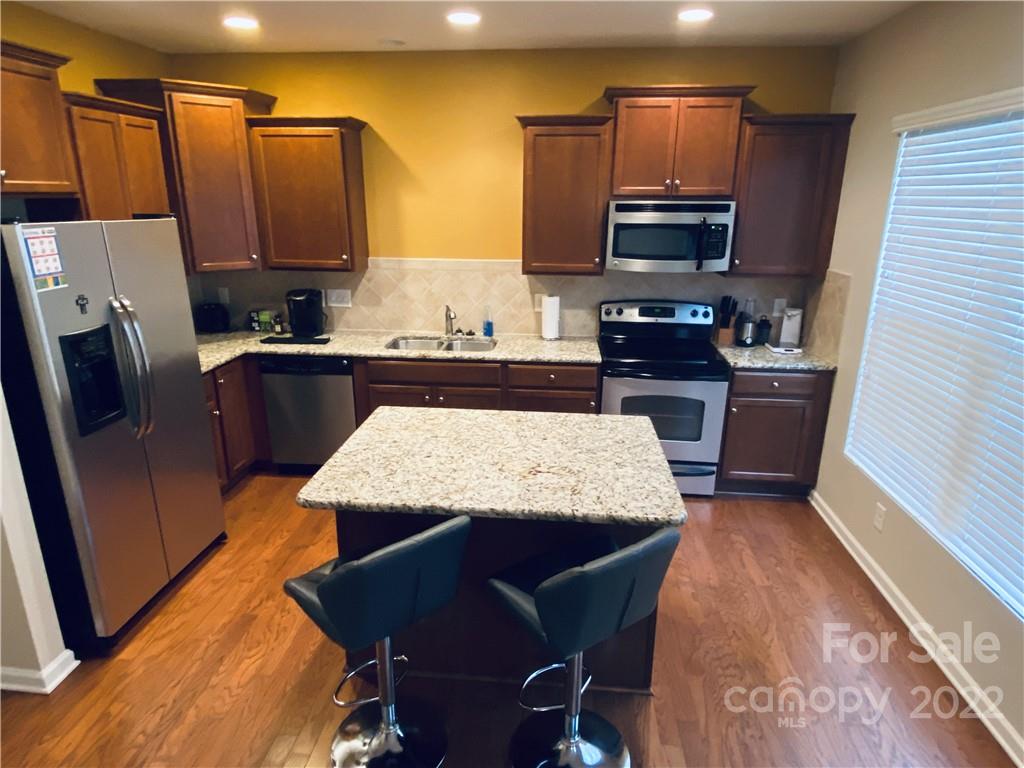5604 Whitehawk Hill Road Mint Hill, NC 28227 - Photo 2 of 18 a kitchen with stainless steel appliances granite countertop a refrigerator a stove top oven a sink and dishwasher