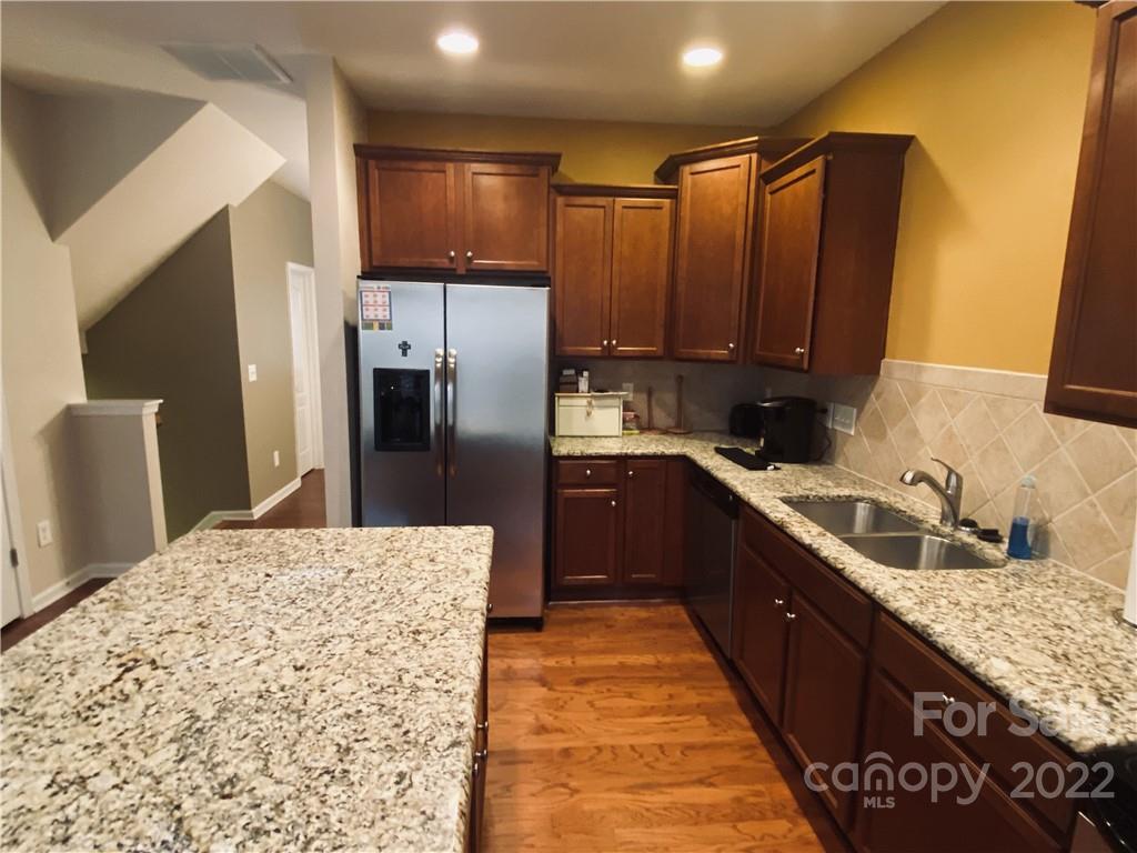 5604 Whitehawk Hill Road Mint Hill, NC 28227 - Photo 3 of 18 a large kitchen with stainless steel appliances kitchen island granite countertop a refrigerator and a sink