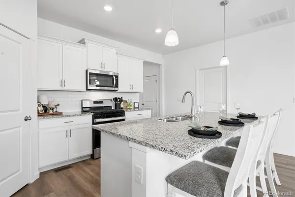 a kitchen with stainless steel appliances granite countertop a stove a sink and a refrigerator