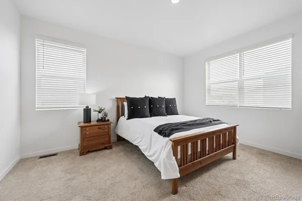 a bedroom with a bed lamp and window