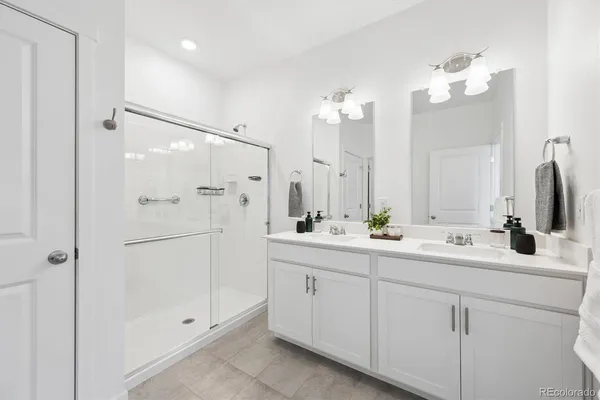 a bathroom with a double vanity sink mirror and shower