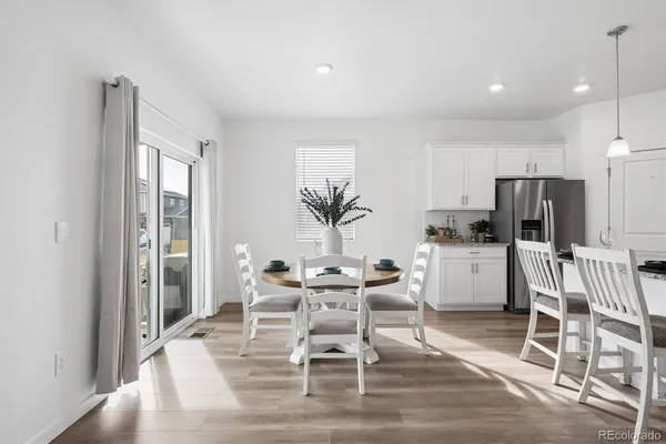 a dining room with furniture and kitchen view