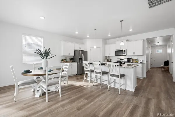 a living room with furniture and kitchen view with wooden floor