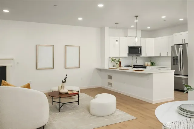 a kitchen with kitchen island a white counter top space cabinets and stainless steel appliances
