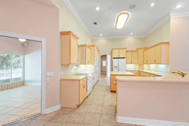 a kitchen with white cabinets and refrigerator