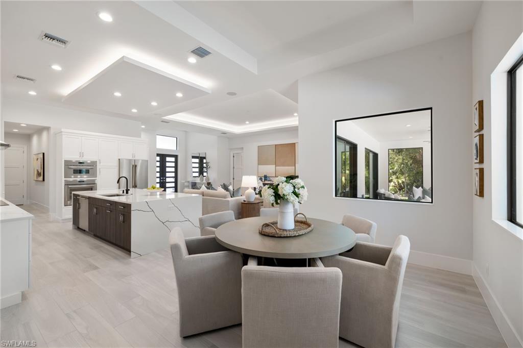 4751 1st Avenue Southwest Naples, FL 34119 - Photo 14 of 36 a view of a dining room with furniture window and wooden floor