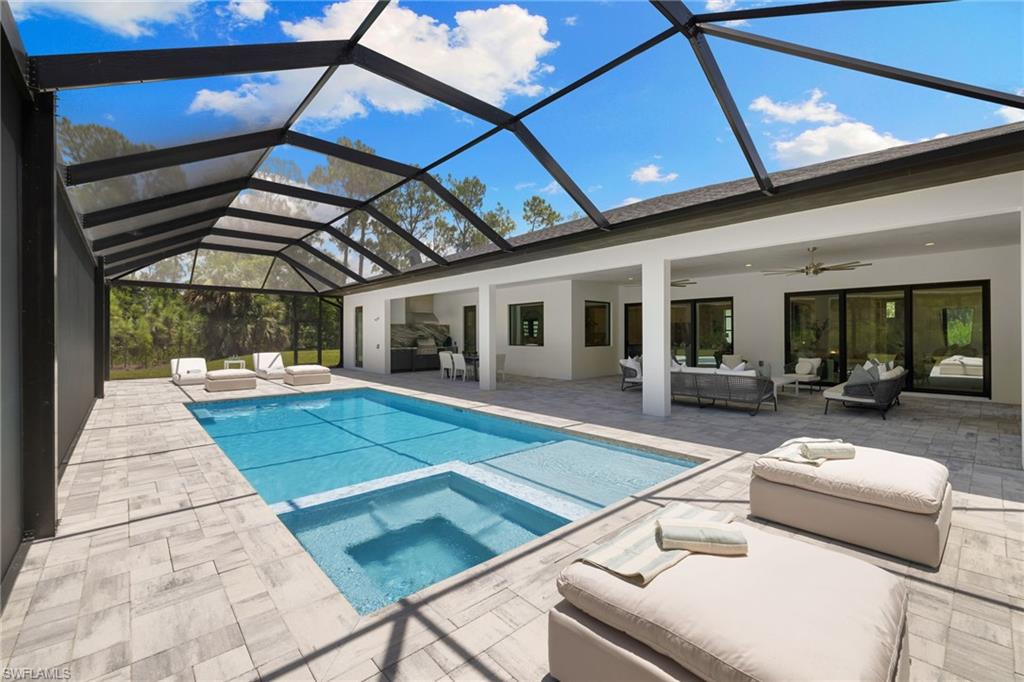 4751 1st Avenue Southwest Naples, FL 34119 - Photo 16 of 36 a view of a patio with couches table and chairs with wooden floor and fence