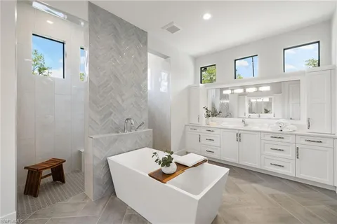 a bathroom with a tub sink and mirror