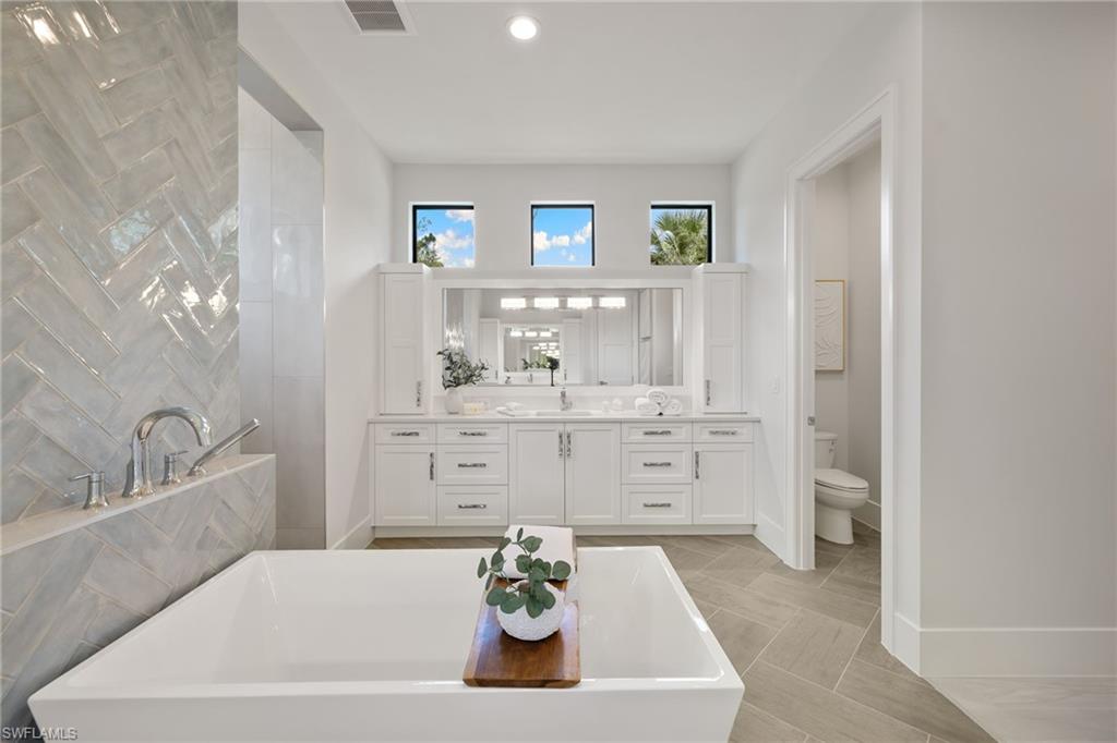4751 1st Avenue Southwest Naples, FL 34119 - Photo 25 of 36 a bathroom with a tub sink and mirror