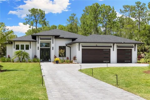 a front view of a house with yard and green space
