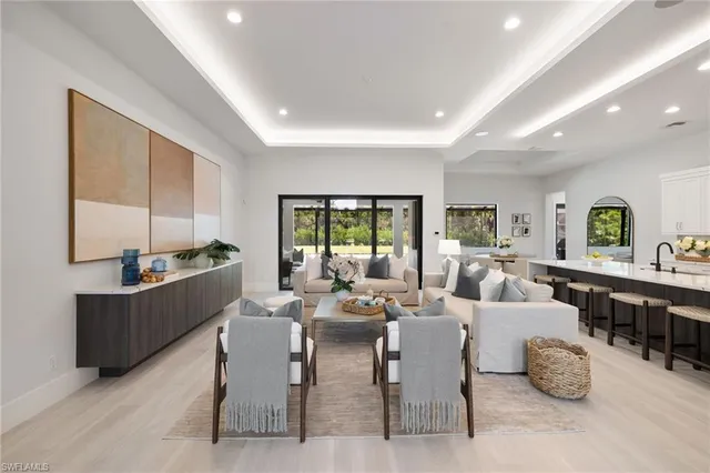 a living room with furniture kitchen view and a large window