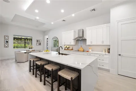 a kitchen with a dining table chairs and white cabinets