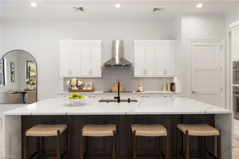 a kitchen with stainless steel appliances a sink and white cabinets