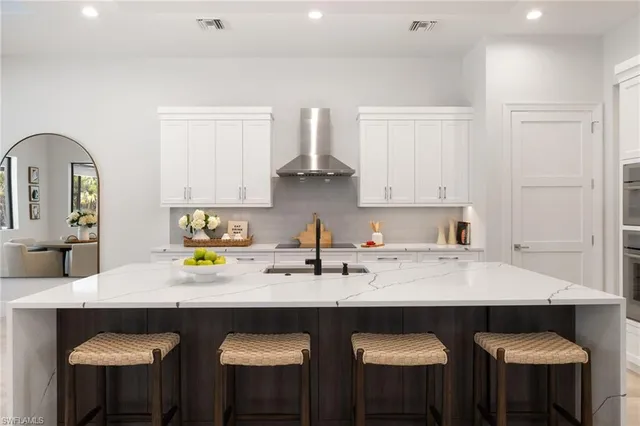 a kitchen with stainless steel appliances a sink and white cabinets