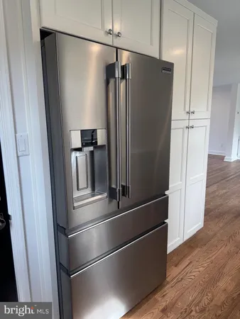 a metallic refrigerator freezer sitting in a kitchen