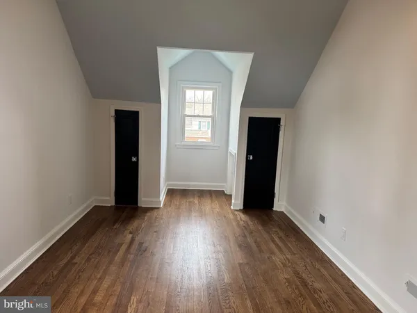 an empty room with wooden floor and closet