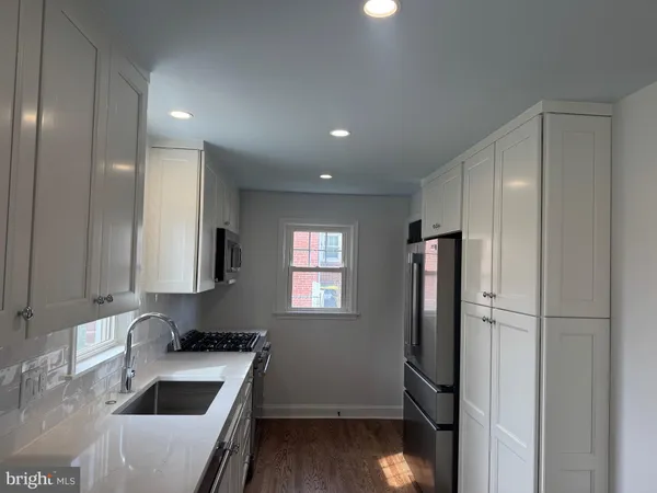 a kitchen with stainless steel appliances granite countertop a refrigerator and a sink
