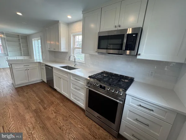 a kitchen with sink a microwave and cabinets