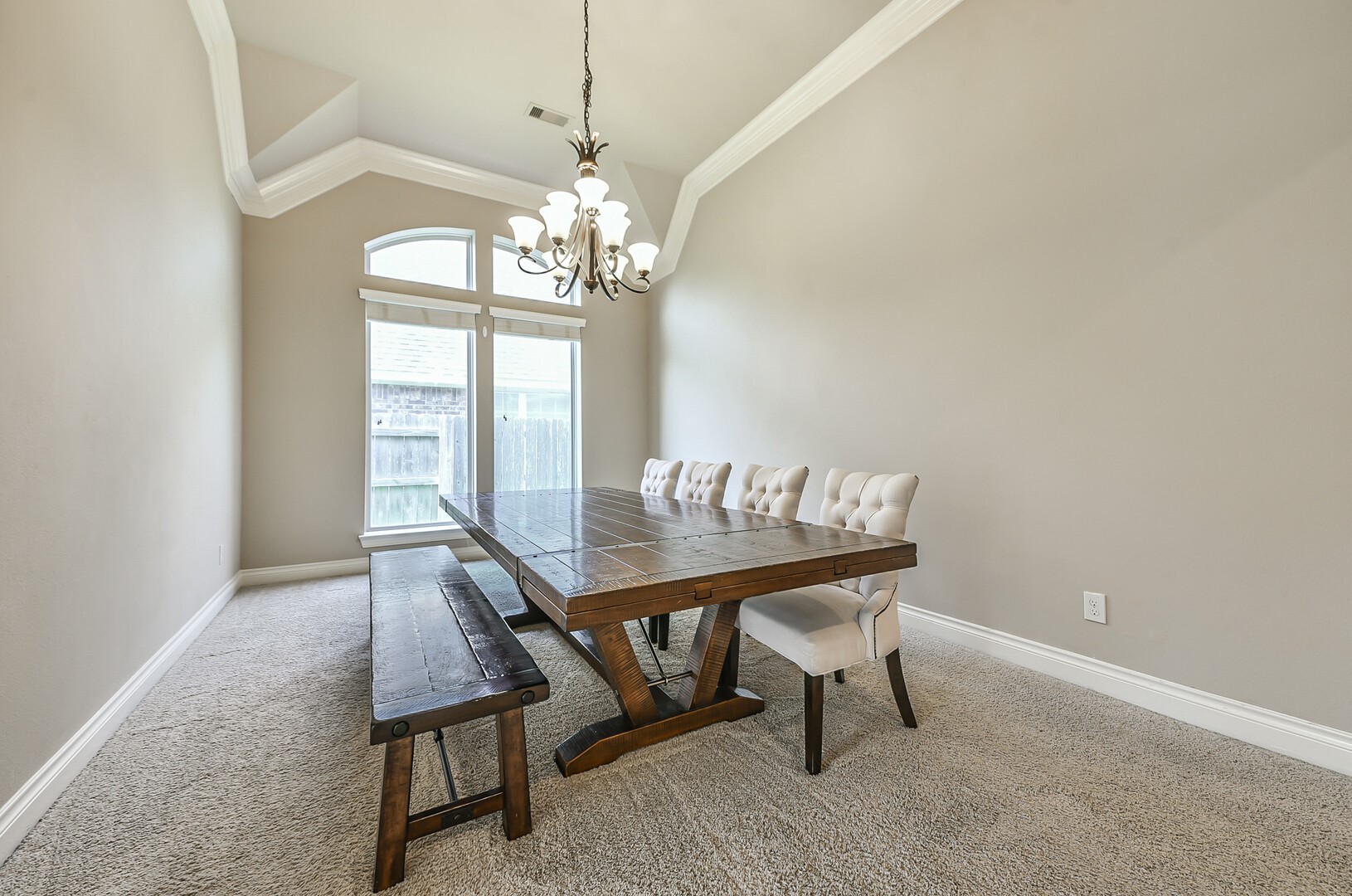 10323 Belvamera Road Richmond, TX 77407 - Photo 11 of 25 This formal dining room features a high ceiling with crown molding, a large window for natural light, and a stylish chandelier.