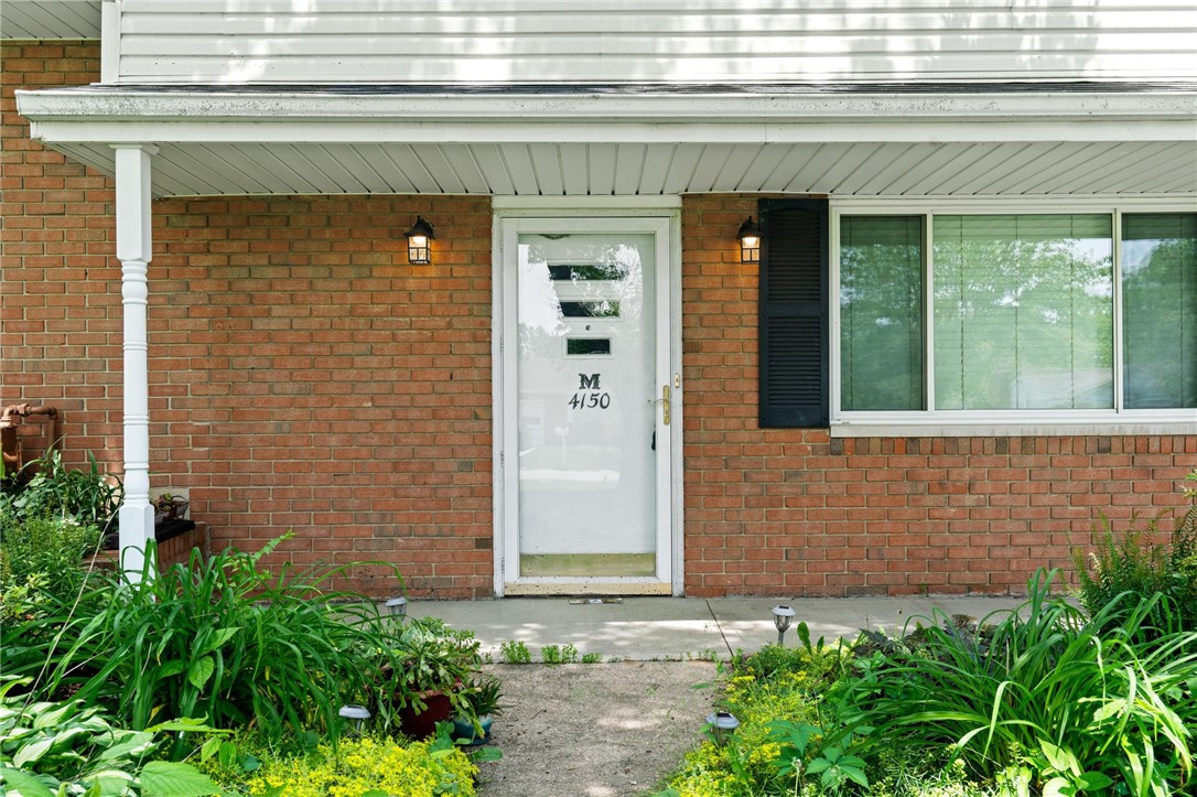 4150 Rose Marie Road Franklin, OH 45005 - Photo 10 of 36 A classic brick exterior with a welcoming porch and vibrant green landscaping.