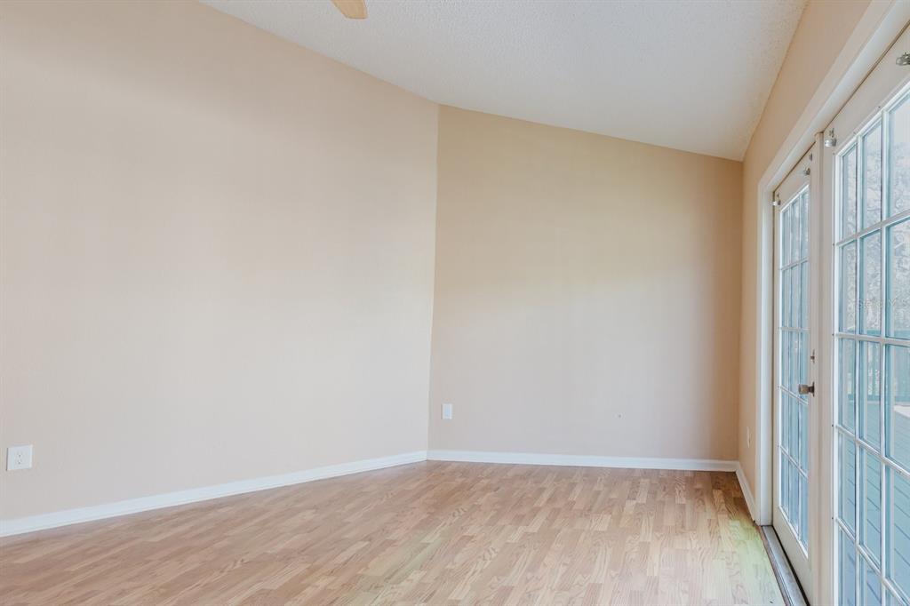 7804 Wilmar Court Port Richey, FL 34668 - Photo 18 of 82 a view of an empty room with wooden floor and a window