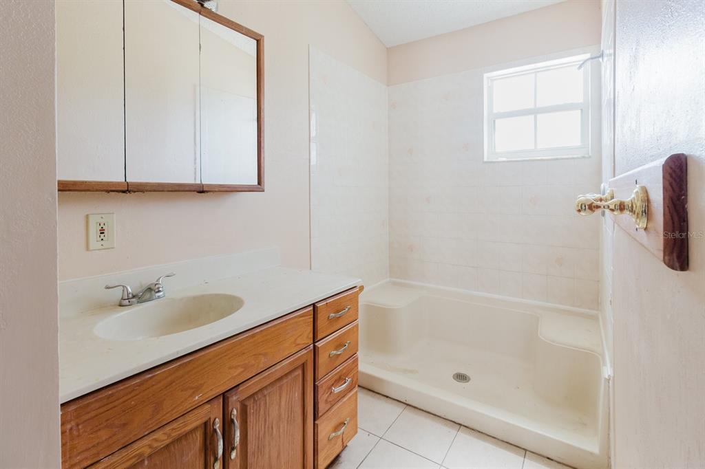7804 Wilmar Court Port Richey, FL 34668 - Photo 21 of 82 a bathroom with a bathtub sink vanity and mirror