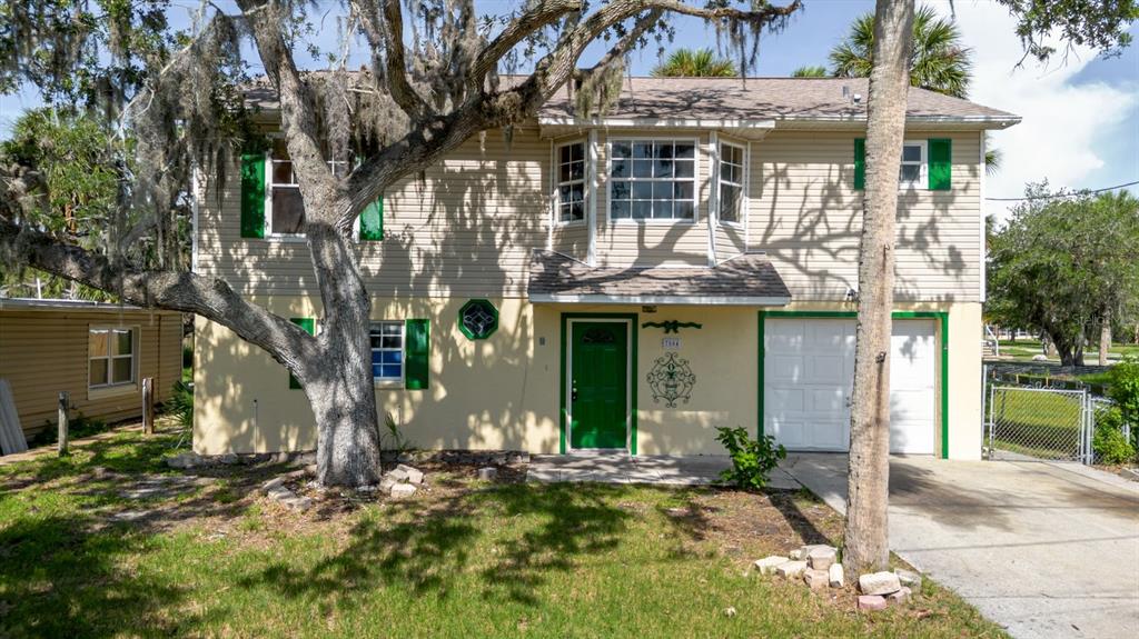 7804 Wilmar Court Port Richey, FL 34668 - Photo 52 of 82 a front view of a house with a yard garage and outdoor seating