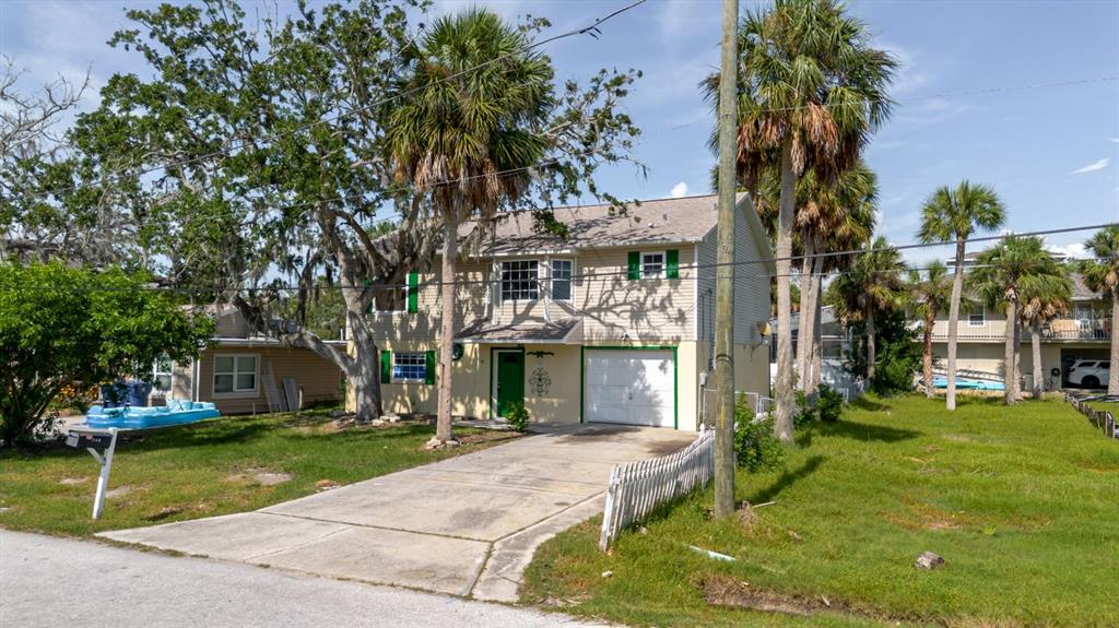 7804 Wilmar Court Port Richey, FL 34668 - Photo 54 of 82 a front view of a house with a yard table and chairs