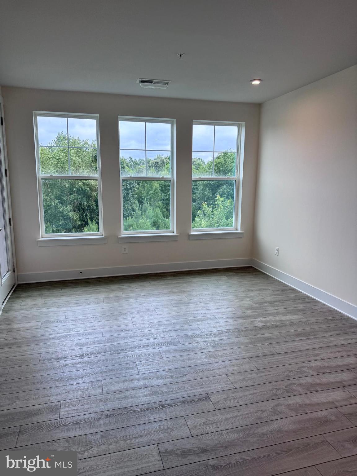 1000 Herons Nest Way, Unit 32 Chester, MD 21619 - Photo 12 of 28 an empty room with wooden floor and windows
