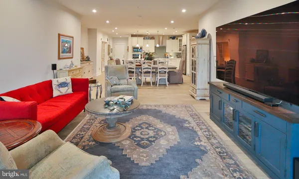 a living room with furniture and a view of kitchen