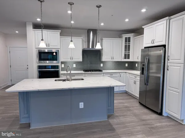 a kitchen with kitchen island a sink stainless steel appliances and cabinets