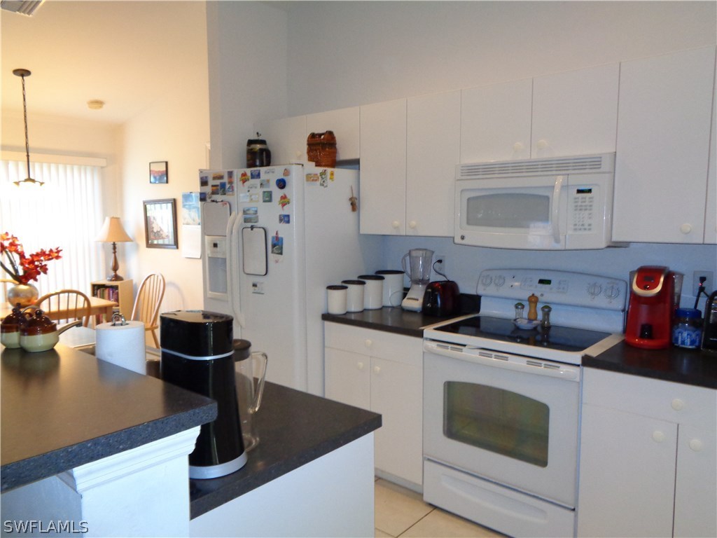 2512 53rd Street West Lehigh Acres, FL 33971 - Photo 14 of 25 a kitchen with stainless steel appliances granite countertop a sink stove and refrigerator