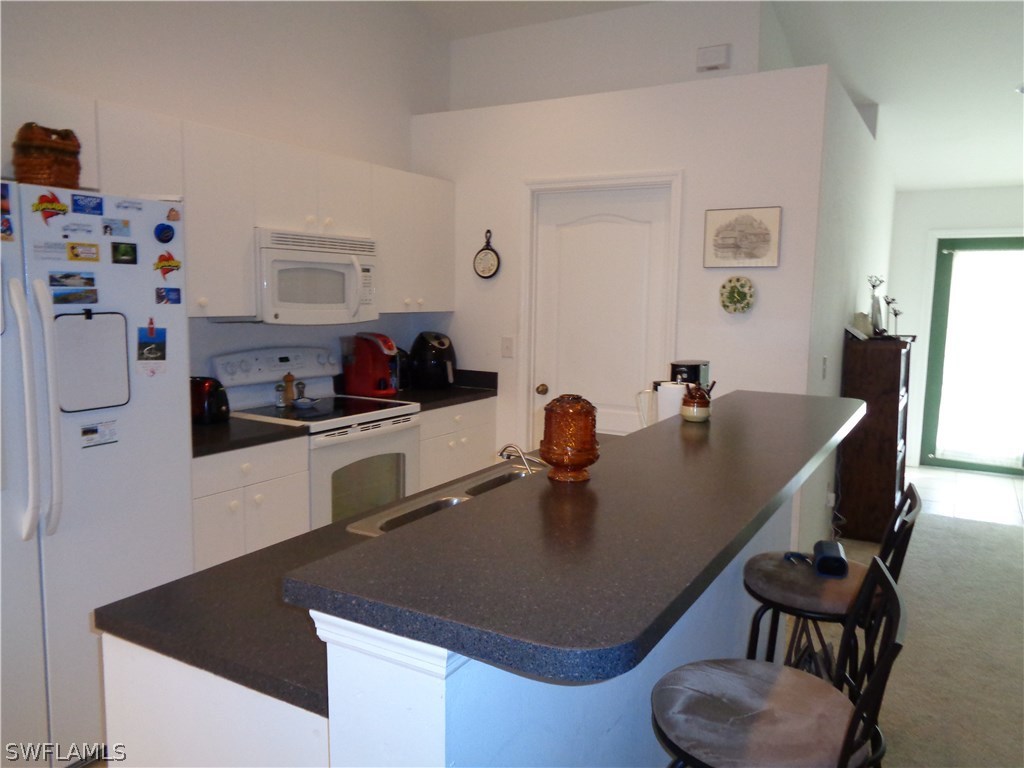 2512 53rd Street West Lehigh Acres, FL 33971 - Photo 15 of 25 a kitchen with a table chairs and a refrigerator