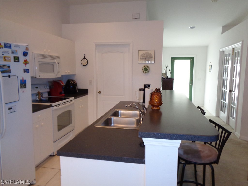2512 53rd Street West Lehigh Acres, FL 33971 - Photo 16 of 25 a kitchen with a white cabinets and white appliances