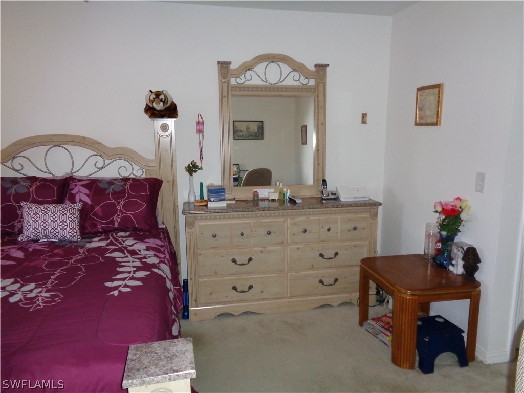 2512 53rd Street West Lehigh Acres, FL 33971 - Photo 18 of 25 a bed room with a bed and a mirror