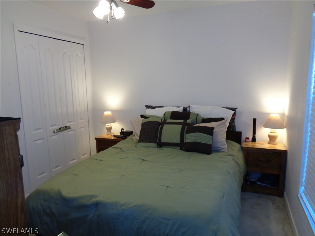 2512 53rd Street West Lehigh Acres, FL 33971 - Photo 20 of 25 a bedroom with a bed and a chandelier