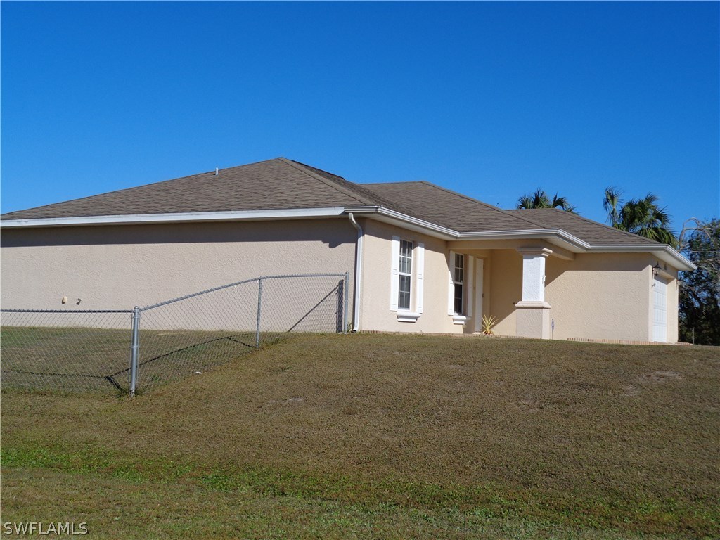 2512 53rd Street West Lehigh Acres, FL 33971 - Photo 3 of 25 a front view of a house with a yard