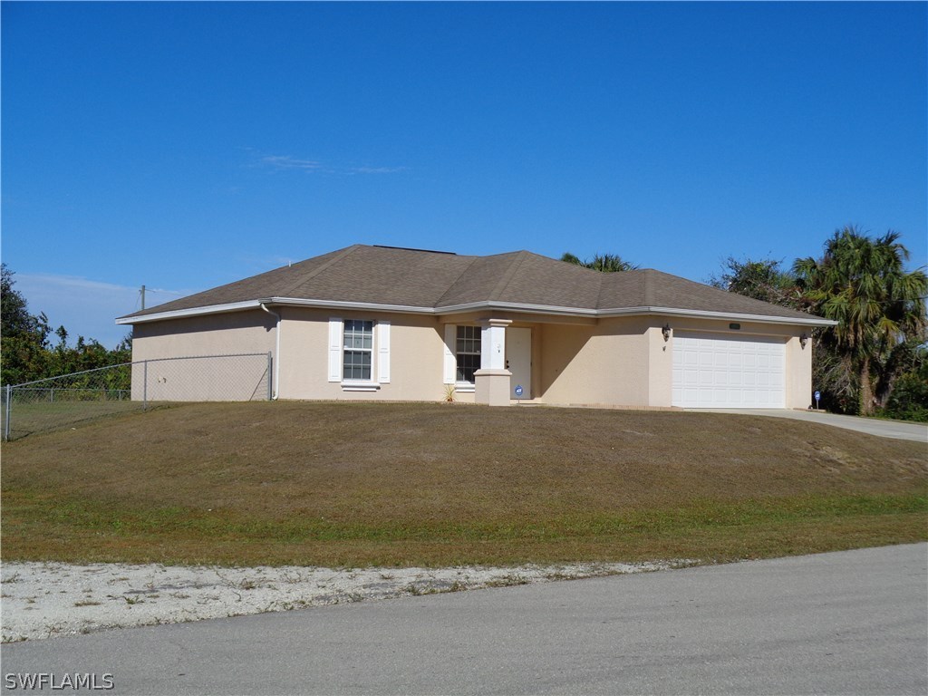 2512 53rd Street West Lehigh Acres, FL 33971 - Photo 4 of 25 a front view of a house with a yard and garage