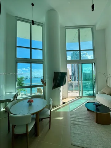 a living room with furniture and a floor to ceiling window