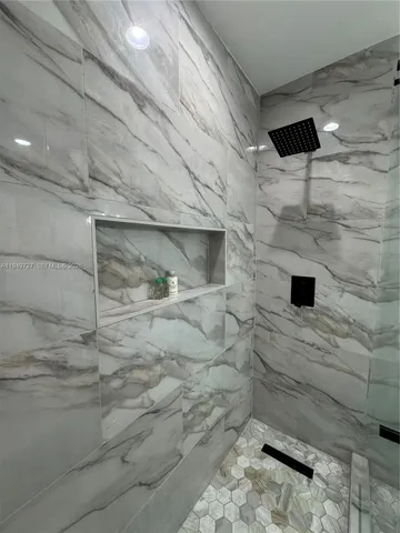 a bedroom with a bed and a flat tv screen on the dresser