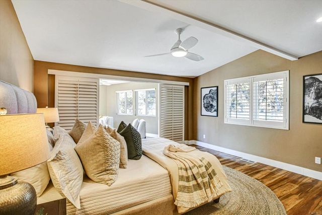 a bedroom with a large bed and wooden floor