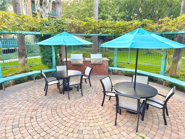 a patio with a table and chairs under an umbrella