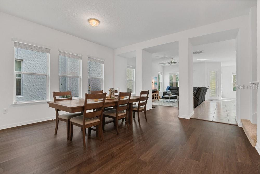 12880 Westside Vlg Loop Windermere, FL 34786 - Photo 12 of 42 a dining room with furniture wooden floor a rug and a painting