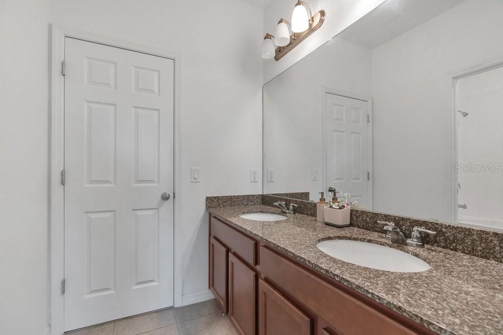 12880 Westside Vlg Loop Windermere, FL 34786 - Photo 25 of 42 a bathroom with a granite countertop sink and a mirror