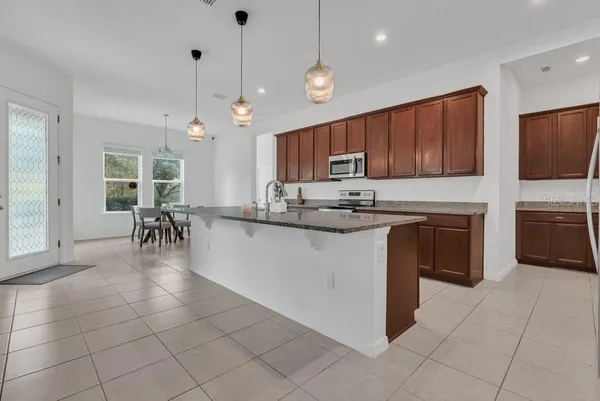 a kitchen with stainless steel appliances granite countertop a stove a sink a microwave and a refrigerator