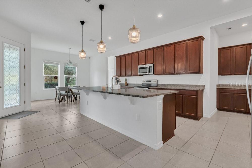 12880 Westside Vlg Loop Windermere, FL 34786 - Photo 8 of 42 a kitchen with stainless steel appliances granite countertop a stove a sink a microwave and a refrigerator