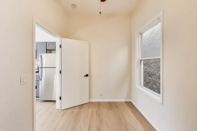 a view of hallway with window and wooden floor