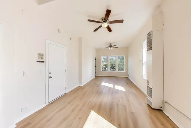 a view of empty room with wooden floor and window