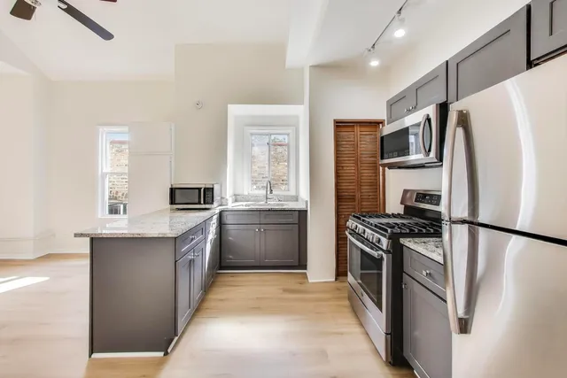 a kitchen with stainless steel appliances granite countertop a refrigerator a stove a sink and a refrigerator