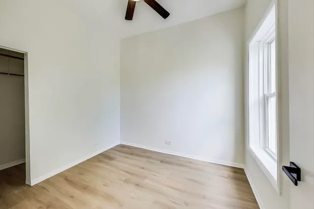 an empty room with a window and wooden floor